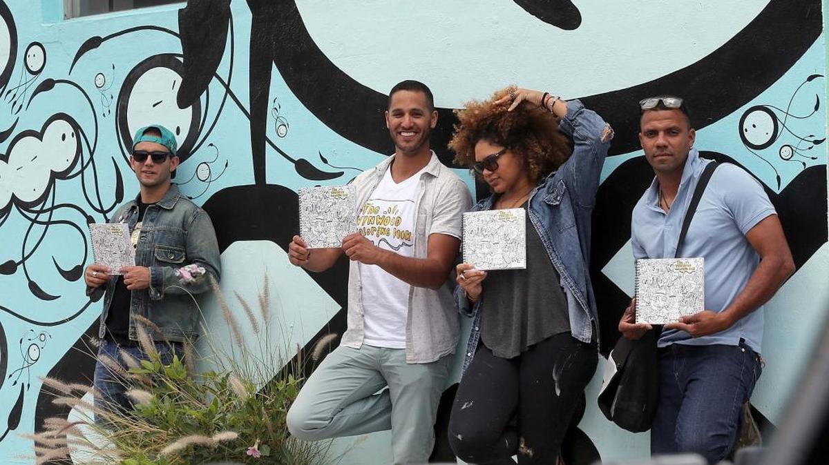 De izq. a der.: los artistas plásticos GG, Diego Orlandini, Jenny Perez y Will Rodríguez frente a uno de los murales incluidos en el libro ‘Wynwood Coloring Book’, que invita a las personas a relajarse y despertar su creatividad inspirándose en el arte callejero de este vecindario de Miami.