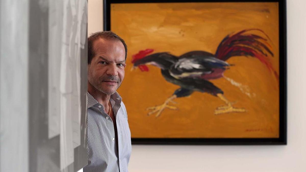 El doctor Julio Gallo entre dos piezas de los artistas cubanos María Martínez Cañas (izq.) y Tomás Esson, parte de su colección de arte.