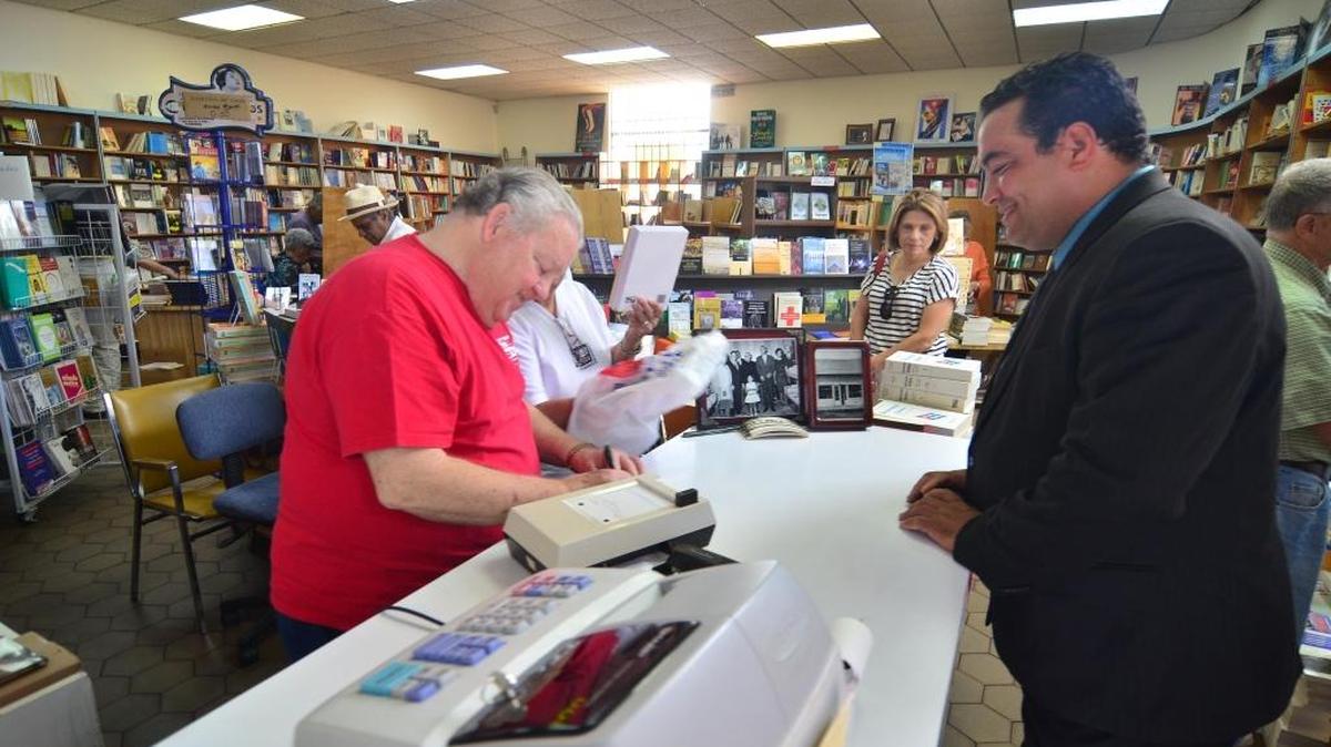 Juan Manuel Salvat, dueño de la Librería Universal y del sello editorial del mismo nombre, entrega un recibo a un cliente el Día de los Padres del 2013, cuando cerró el negocio.