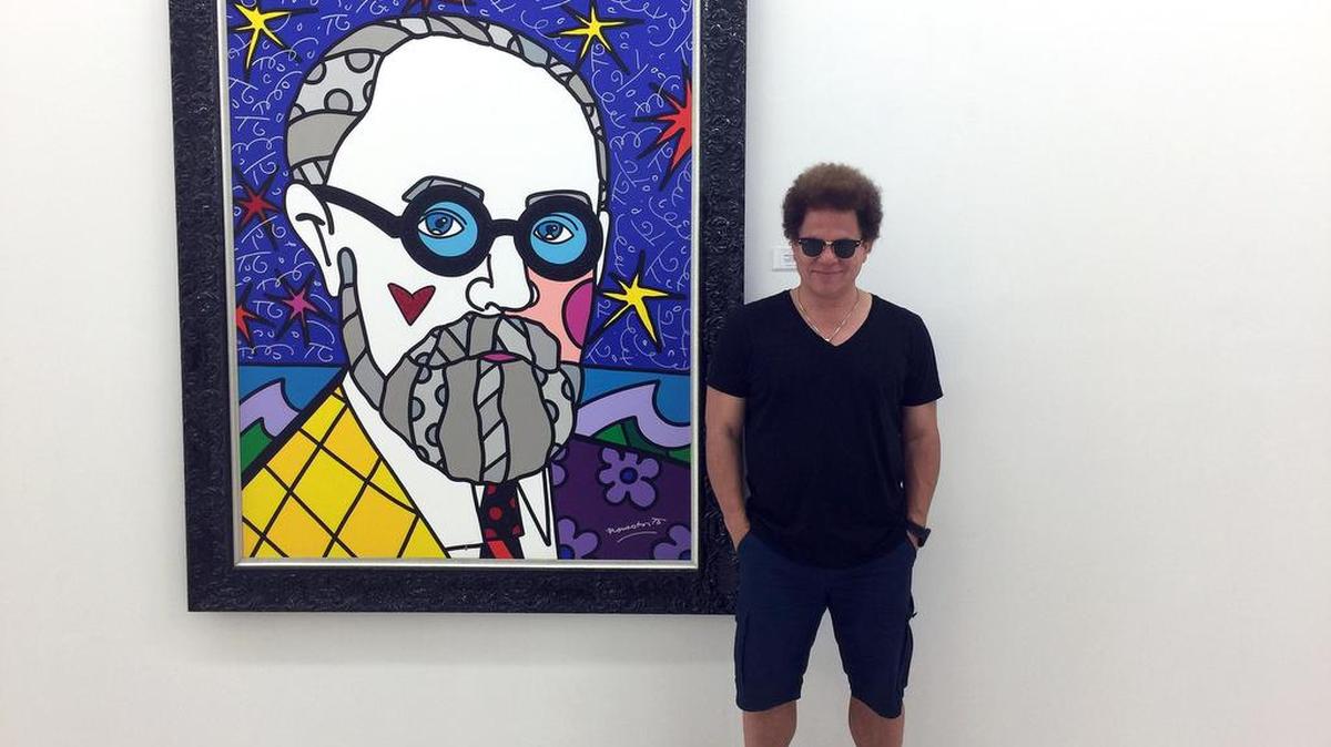 El pintor neo pop brasileño Romero Britto posa frente a un retrato suyo del pintor Henry Mattise en el Museo de Arte Latinoamericano (NAMLA) en Miami.