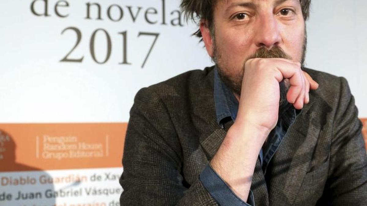 Fotografía facilitada por Alfaguara del escritor madrileño Ray Loriga, que posa junto al cartel de la XX edición del Premio Alfaguara de novela.