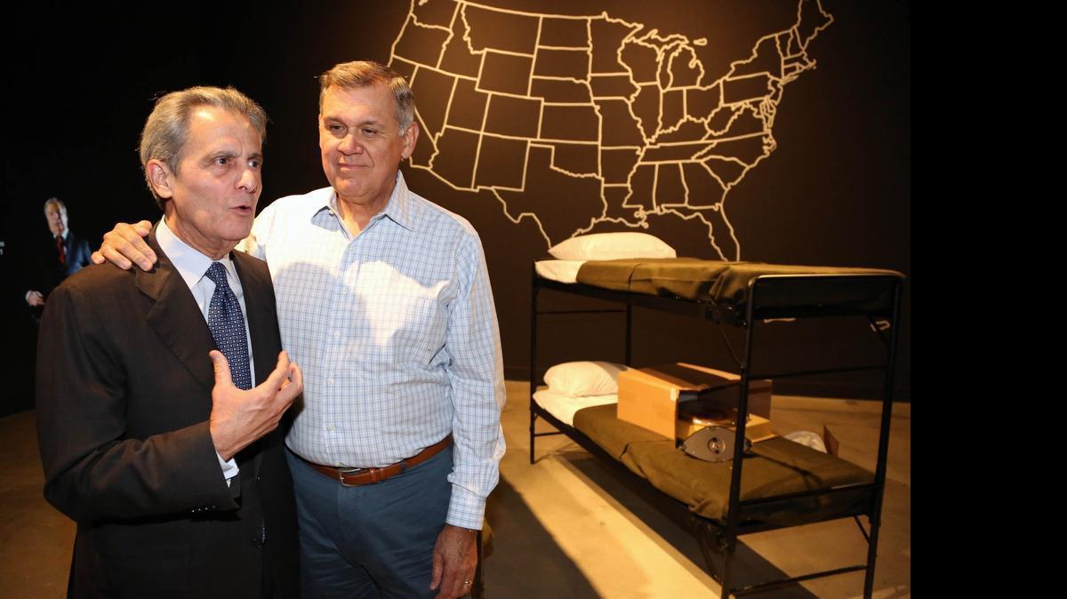 
Tony Argiz y Mel Martinez junto a la recreación de los campamentos de Pedro Pan, que se ha hecho en el HistoryMiami.
