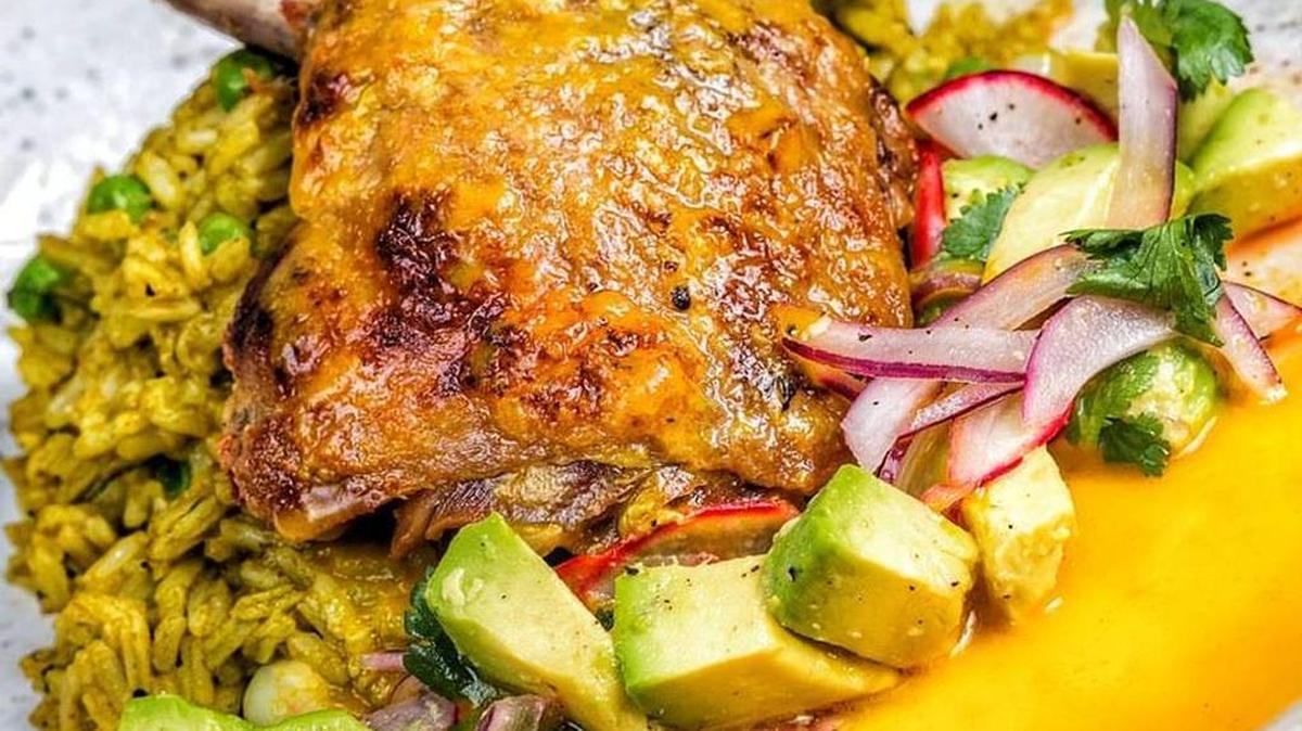 Arroz con pato confitado (pato servido con arroz al cilantro, y ensalada de aguacate, rábanos sandía y cebollas, con vinagreta de ají amarillo y leche de tigre).