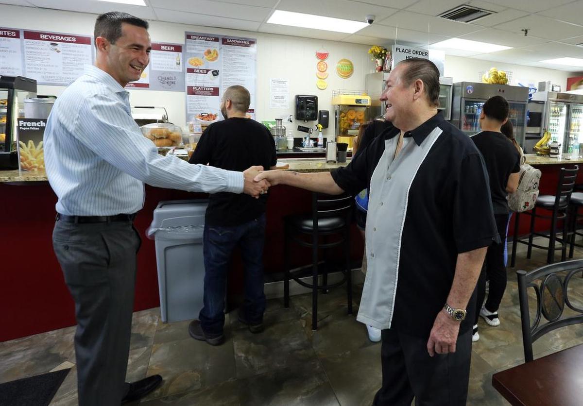 Daniel Torres, un cliente asiduo de Manolo y René, saluda al legendario Manolo Lirio en el nuevo local del restaurante.