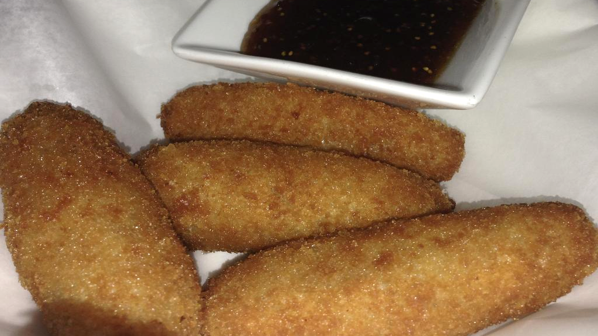 
Fotografía de un plato de croquetas de bechamel con quesos fontina, parmesano y chorizo del restaurante Cena by Michy que es la sorpresa de este verano en Miami (EE.UU.), la más reciente apuesta de la reconocida chef argentino-judía Michelle Bernstein, siempre inquieta, incansable, una cocinera de nervio que cuenta con una legión de partidarios. El itinerario gastronómico de verano en Miami conduce necesariamente a locales donde se privilegia la frescura de la materia prima, una cocina de platos ligeros, sanos y ricos para escapar del calor rabioso que muerde la ciudad estos meses. Los que nacieron para morir comiendo, es decir, aquellos pertenecientes a la hermandad sanchopancesca, encuentran también en el sofocante verano subtropical de Miami reconfortantes paradas donde dar asalto a platos de verano. Pues bien, esta ruta por la fresca vitalidad de la cocina de Miami nos lleva a establecimientos de cocina mediterránea y de otras latitudes donde se apela a los ceviches y tiraditos (La Mar by Gastón Acurio), las ensaladas y el gazpacho (Tuyo), el tartar de atún (Klima), bacalao o res, el pulpo, el lujoso marisco (Joey's) o los pescados y verduras (Cena by Michy) a la plancha o al horno.
