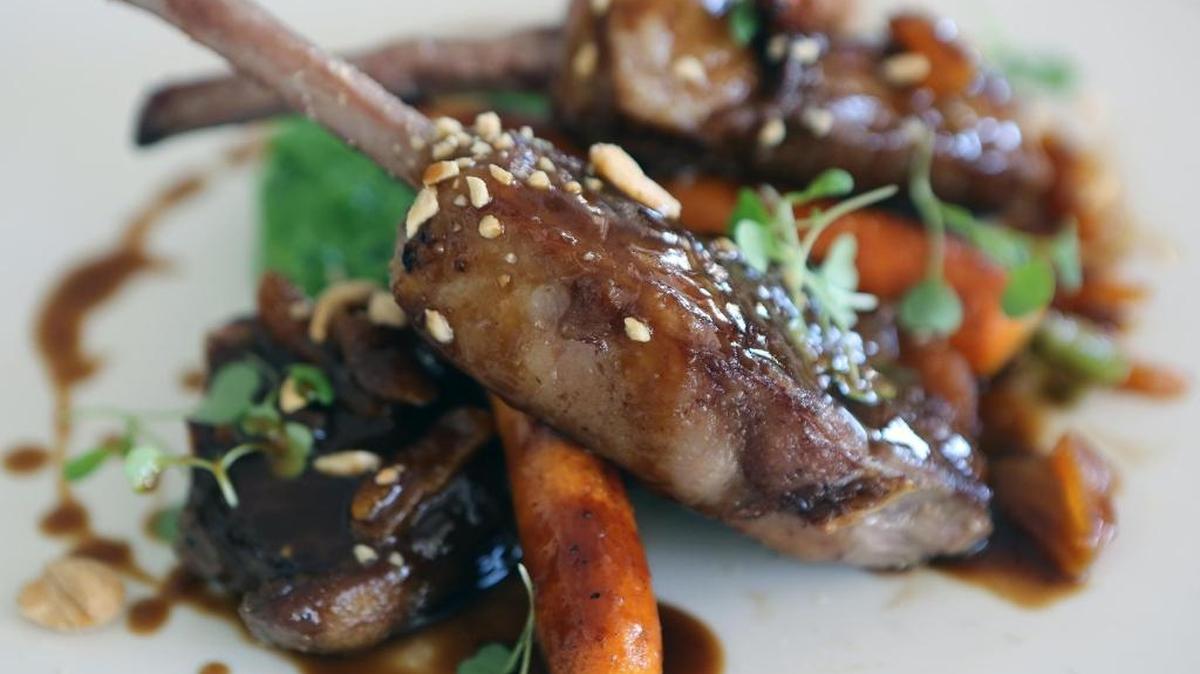 Chuletas de cordero de Colorado con salsa de melocotón, zanahorias glaseadas con miel, puré de guisantes con menta y almendras.