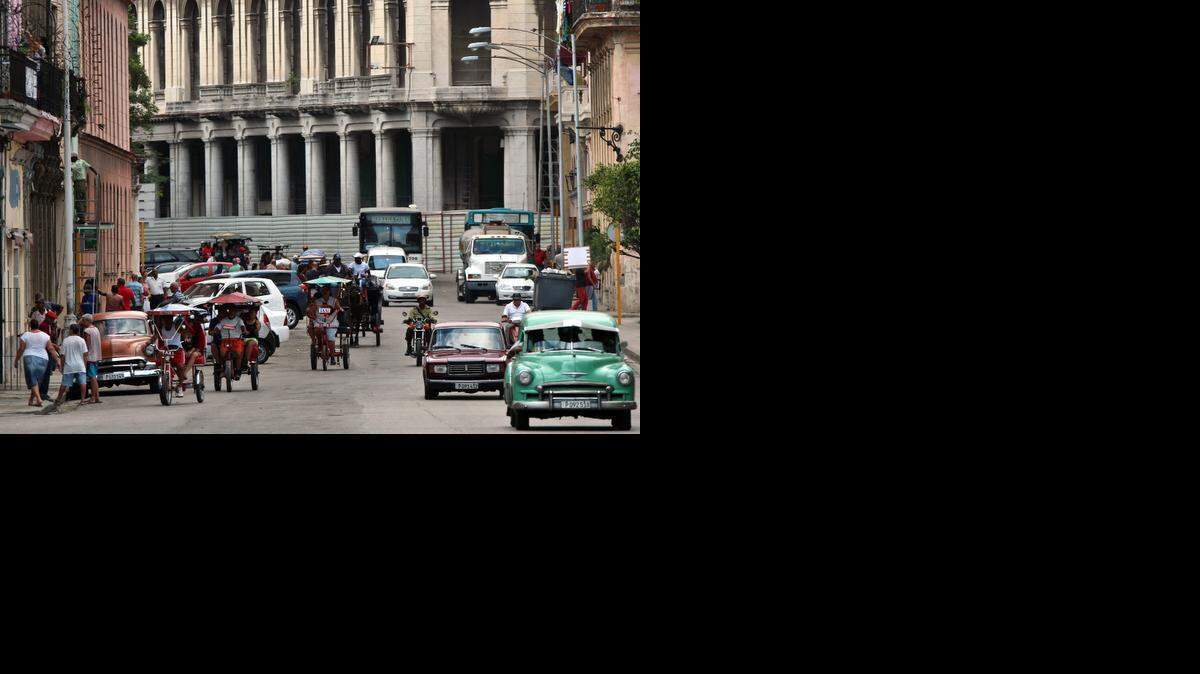 
¿Para qué hacer reformas democráticas, dirán los herederos de Castro, si ya se nos acepta tal y como somos? Varios bicitaxis circulan por una calle de La Habana.
