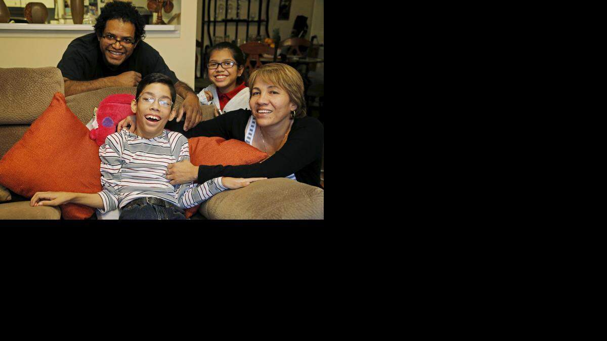 
Michael Angelo Ruiz, al centro, con sus padres, Miguel yand Juanita Ruiz y su hermana Andrea, de 12 años. Michael necesita un cinturón especial para viajar en carro, pero su familia no lo puede pagar.

