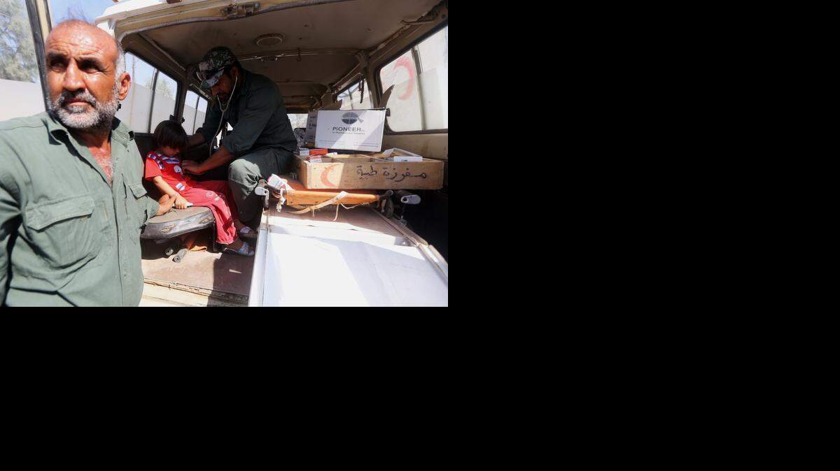 
Un médico voluntario examina a niños en las afueras de Amerli, Irak.


