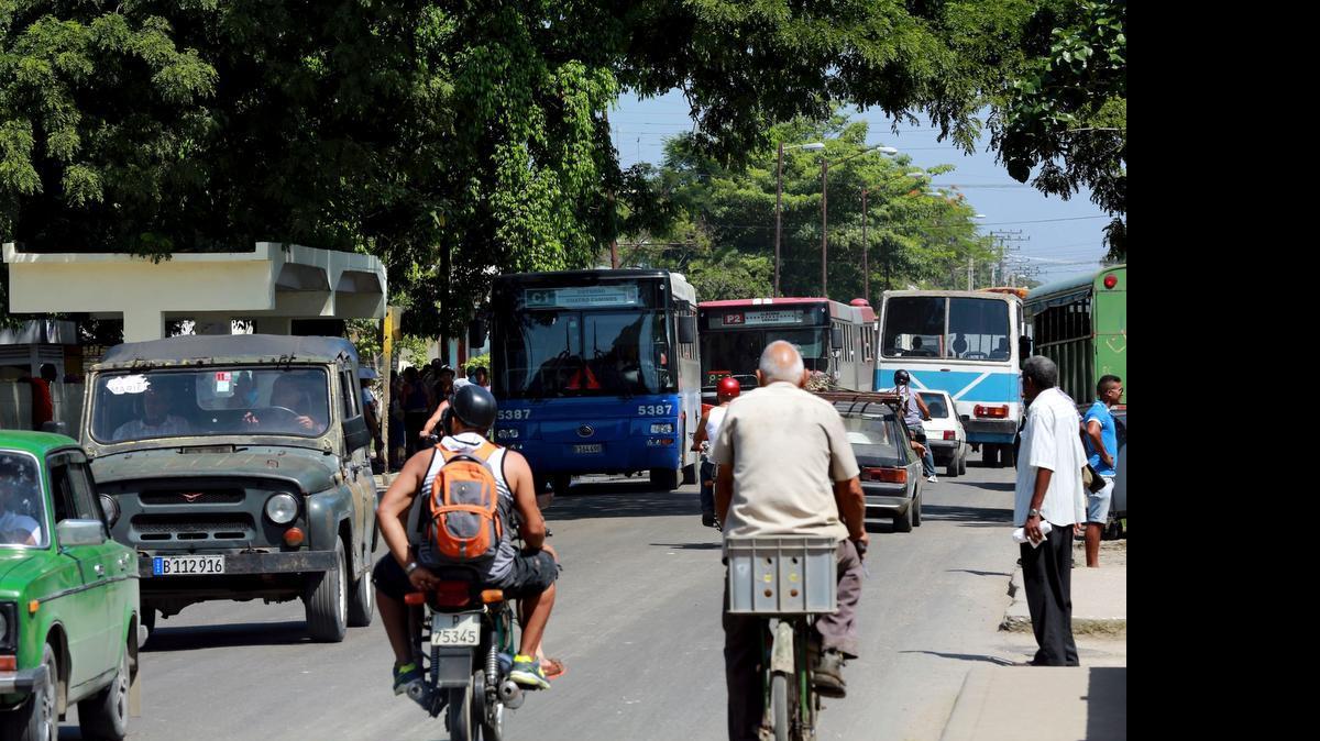 
Ciclistas y vehículos transitan por una calle de La Habana, en junio.
