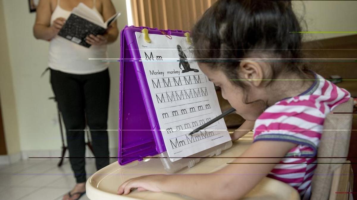 Lisa Marie García hace la tarea sosteniendo el lápiz con la boca.
