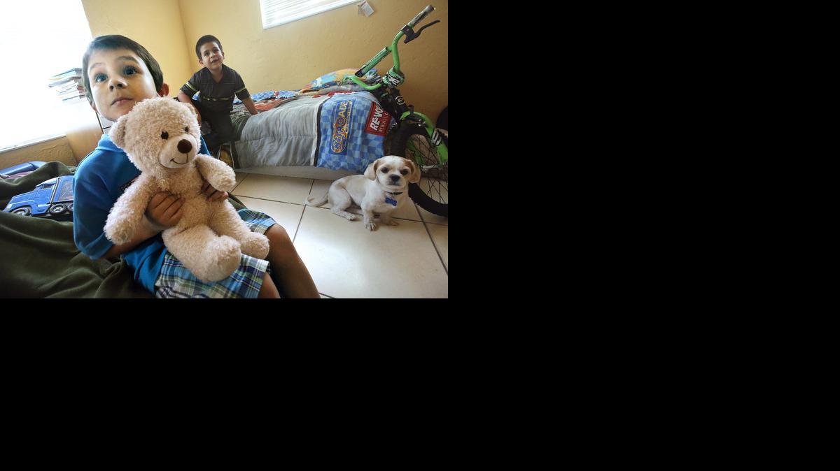 
El pequeño Emanuel con su osito Teddy junto a su hermano Richard, de 8 años, y la mascota de la casa, el perro Jack, en la habitación que ambos comparten en la casa familiar.


