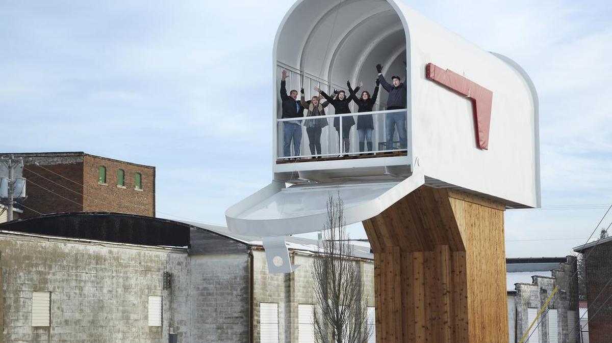 Un grupo de personas subidas al buzón más grande del mundo, en la ciudad de Casey.