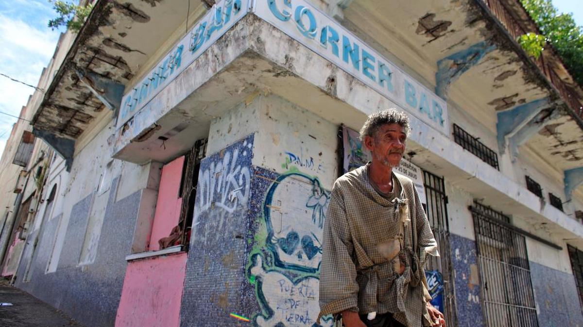 
Un desamparado camina por una sección que tiene numerosos comercios cerrados en Puerta de Tierra, en las afueras del Viejo San Juan, el 2 de agosto. 
