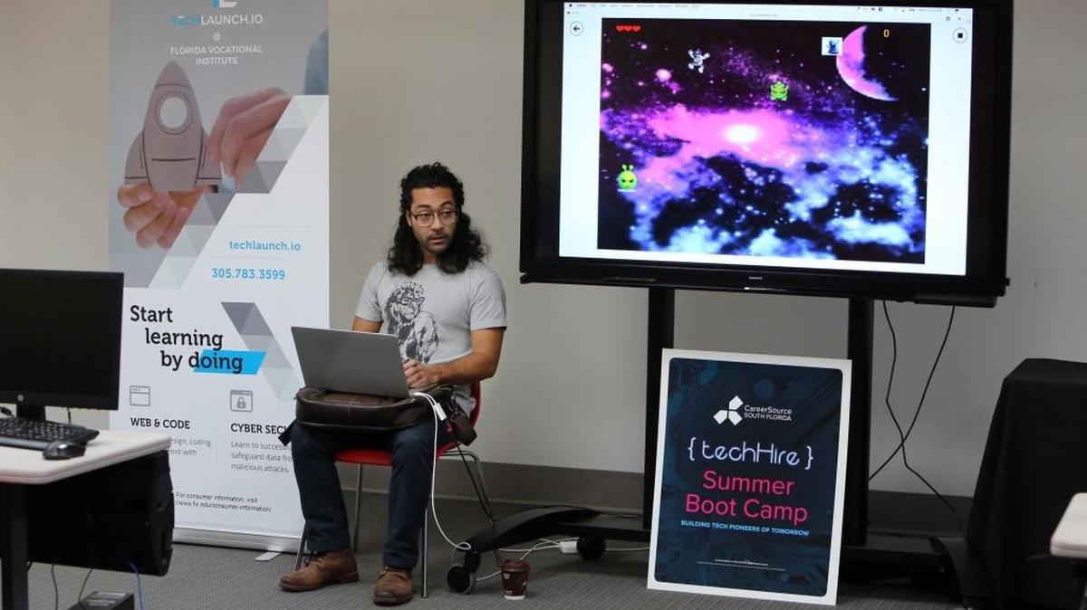 Brenton Cozby, desarrollador de sitios web y maestro de TechLaunch trabaja con estudiantes de un programa de codificación.