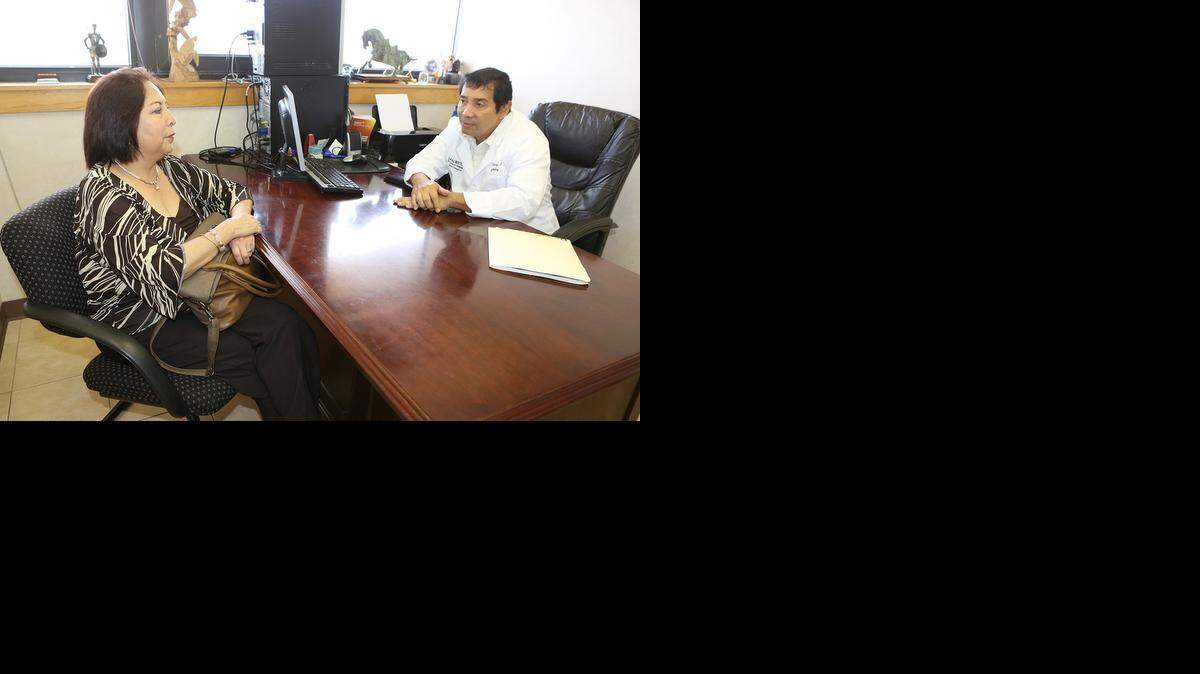 
El Dr. José Gámez conversa con la paciente Margarita Pulido en su consulta. 
