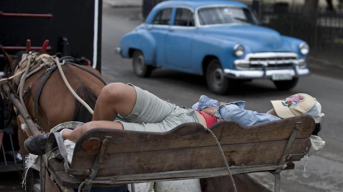 Una mujer se echa una siesta en un carruaje en La Habana, Cuba, el 3 de junio de 2014.