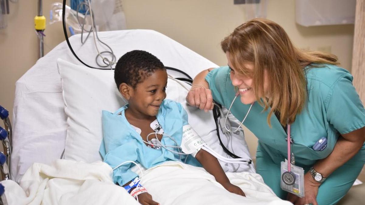 Yvonne Barbato, R.N., conversa con Justin Barracks antes de entrar al quirófano durante el Día de las Sonrisas 2015.