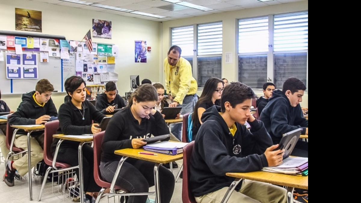 
Ricardo Regueiro, maestro de 7mo grado de educación cívica, utiliza tabletas para enseñar su clase en W.R. Thomas Middle School de Miami. 

