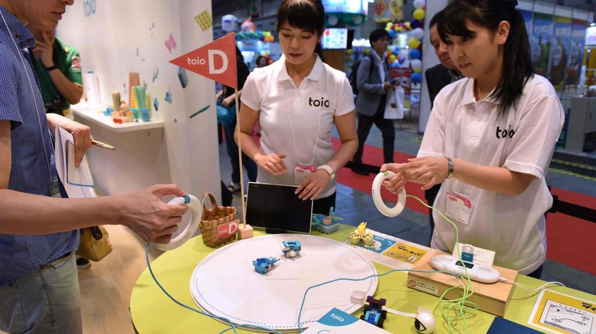Empleados del gigante japonés de la electrónica Sony demuestran la plataforma del juguete "toio" en el Show international del juguete enTokio, el 1 de junio de 2017.