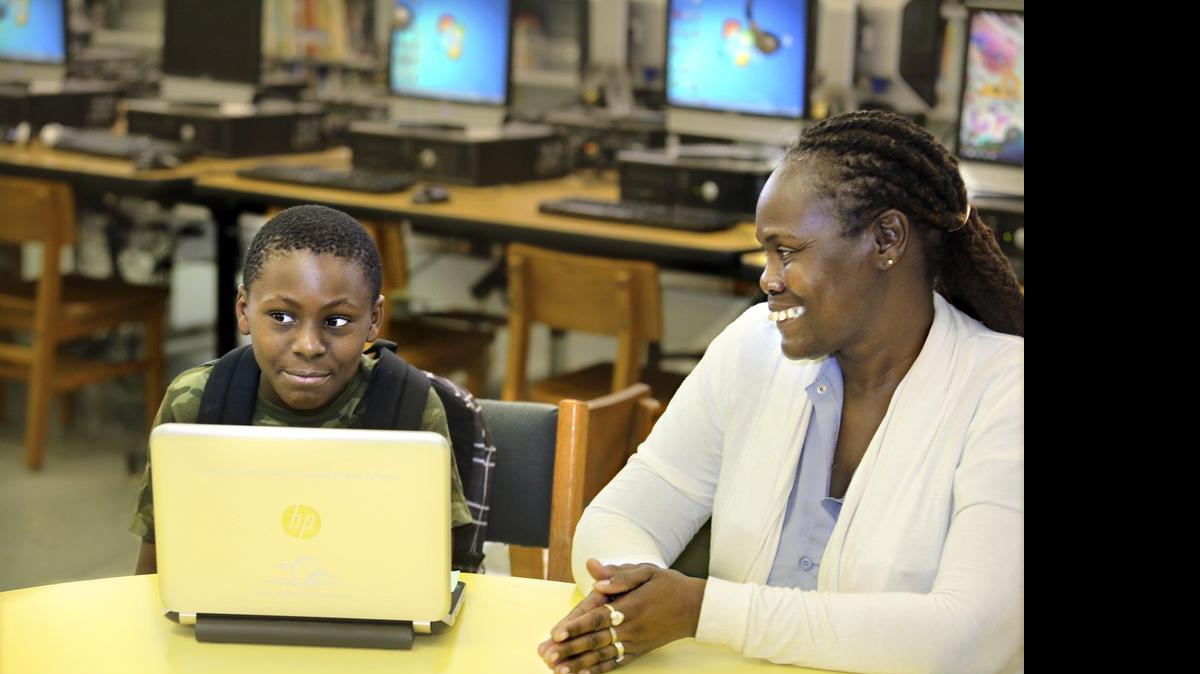 
Christian Fussell junto a su abuela, Phyllis Richburg, en el laboratorio de tecnología de Liberty City Elementary School. Christian se ha beneficiado al recibir la computadora que le entregó la escuela.


