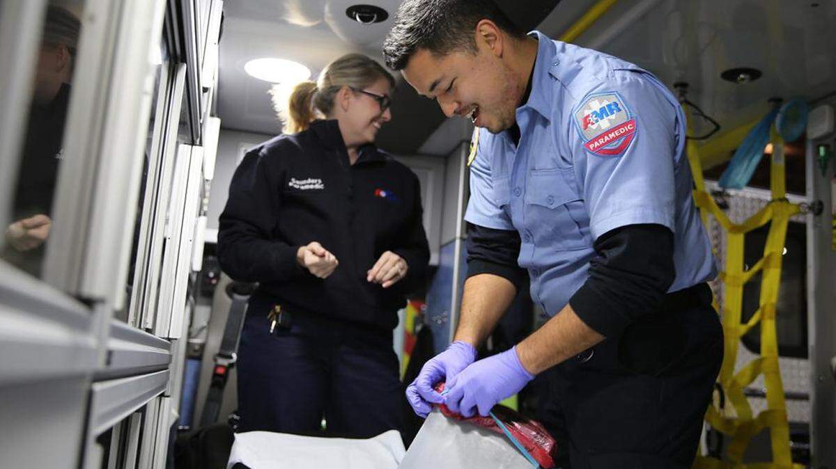 Talitha Saunders y AJ Ikamoto ordenan la ambulancia al final de un turno. Ambos trabajan en el equipo de respuesta a emergencias de American Medical Response, en Portland. Líderes intentan reducir las disparidades basadas en la raza en los tratamientos.