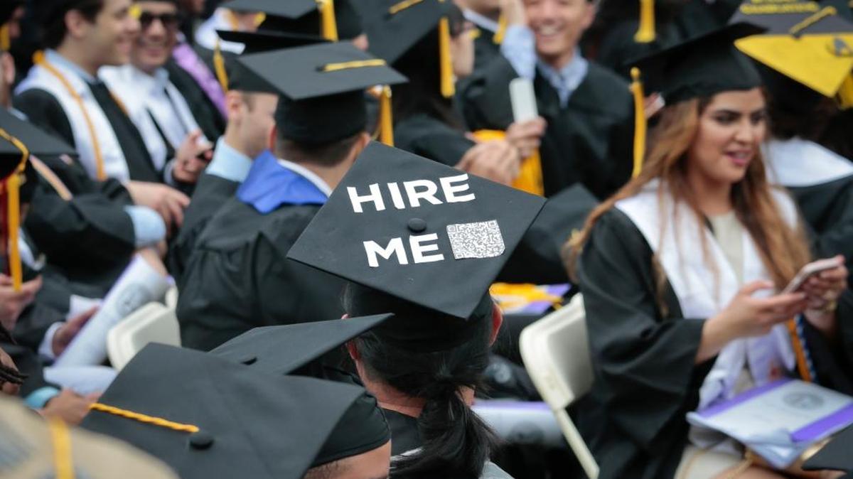 Una graduada de City College of New York (CCNY) clase del 2016 lleva un letrero en el gorro de la toga diciendo ‘contrátame’.