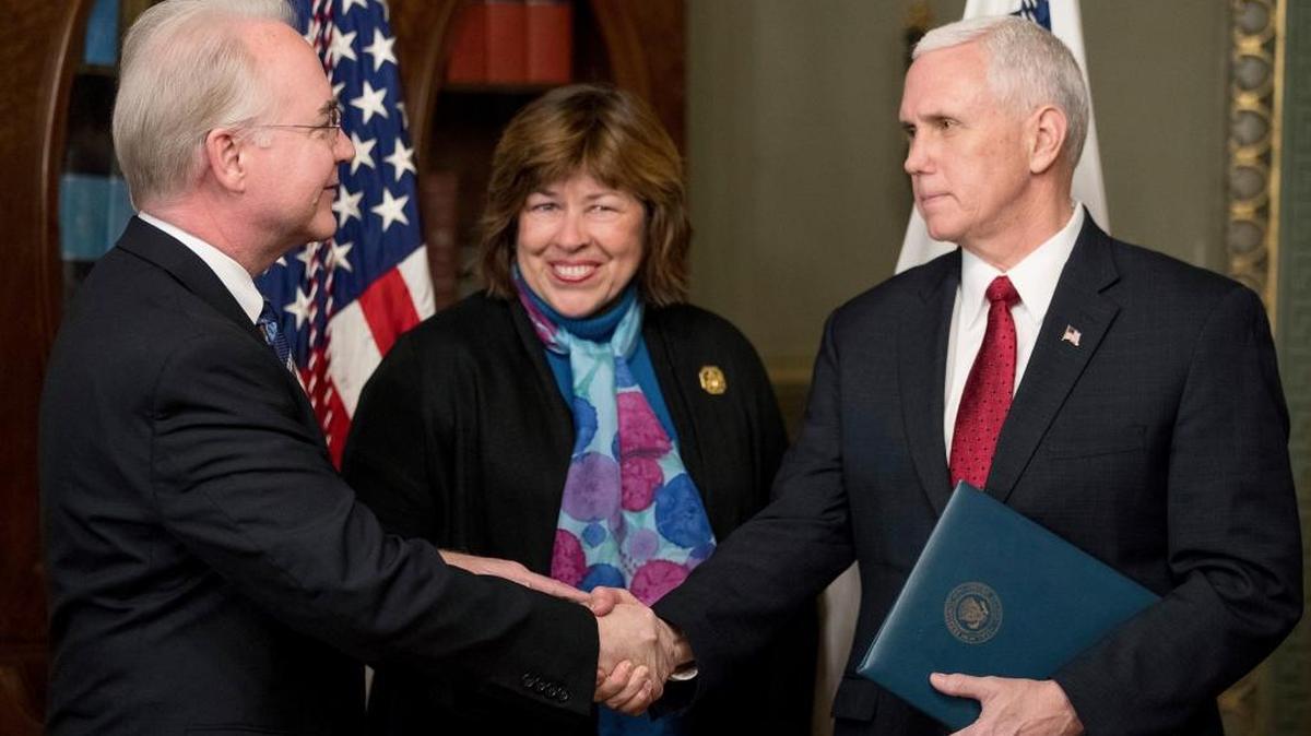 El vicepresidente Mike Pence estrecha la mano del nuevo Secretario Departamento de Salud y Servicios Humanos Tom Price, a quien lo acompaña su esposa Betty.