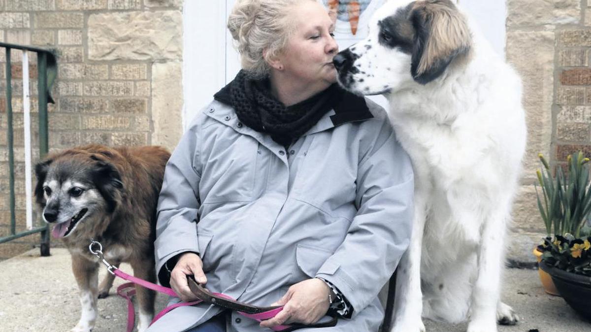 Janine Blezien, con sus dos perros, luego de caminar con ellos por el vecindario. Blezien es una enfermera de un programa de “llamadas de amigo” de un hospital creado durante la pandemia. 