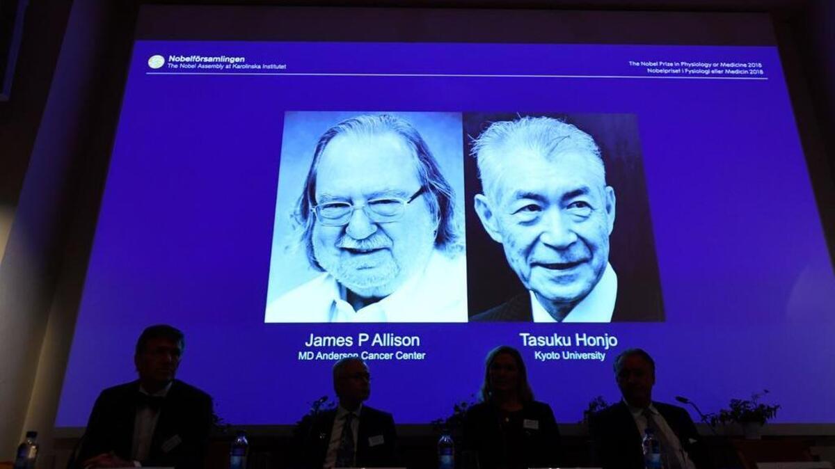 Los miembros del Comité Nobel de Fisiología o Medicina se sientan frente a una pantalla que muestra a James P Allison (L) y Tasuku Honju, los ganadores del Premio Nobel de Fisiología o Medicina 2018, durante una conferencia de prensa en el Instituto Karolinska en Estocolmo, Suecia. , el 1 de octubre de 2018. - James P Allison de EEUU y Tasuku Honjo de Japón ganaron el Premio Nobel de Medicina por sus logros en el tratamiento del cáncer. (
