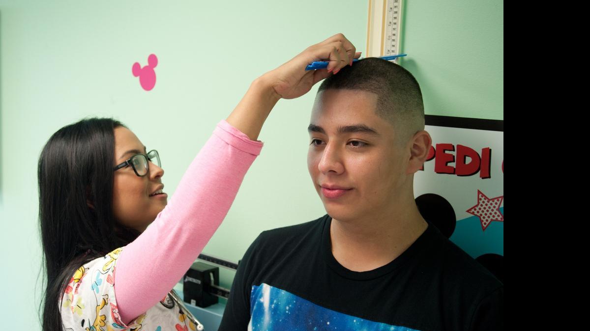 
Gisselle Nogueira, asistente médico del Nicklaus Children's Hospital, mide a José Amaya, de 14 años. José participa de un programa para el manejo de peso que ofrece la División de gastroenterología del hospital.
