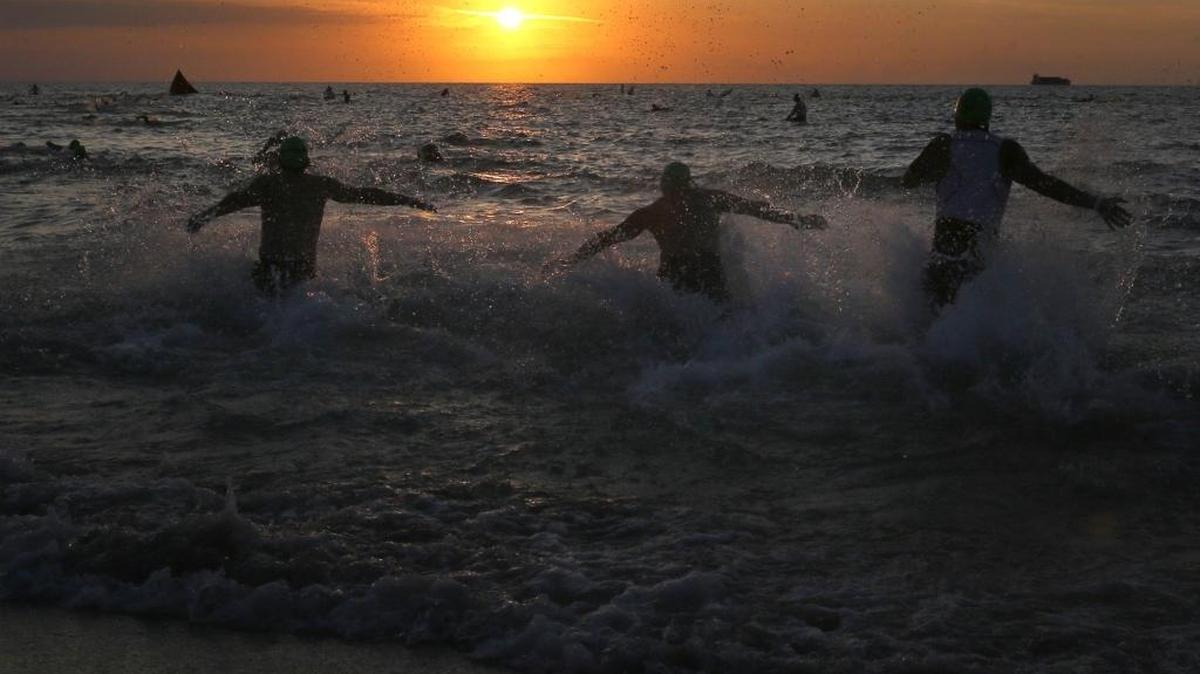 Varios atletas entran al mar como parte de la carrera del triatlón en el 2015.