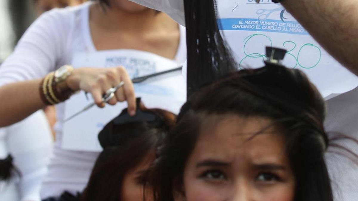 Fotografía de archivo, fechada el 24 de noviembre de 2016, que muestra a estilistas en cortes de cabello masivo en acción, en la Plaza de la Liberación, en la ciudad de Guadalajara (México).