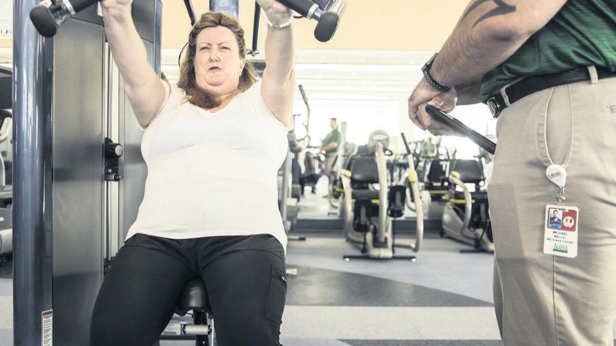 Elizabeth Crucco, psiquiatra geriátrica de UM Miller School of Medicine hace ejercicios levantando pesas mientras.