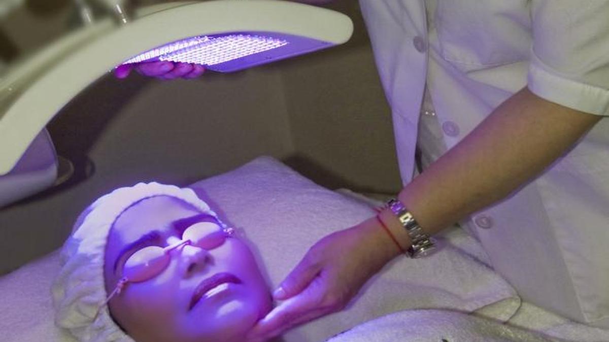 
La doctora Maribel Pedrozo mientras aplica un tratamiento de belleza con luces LED a una paciente.
