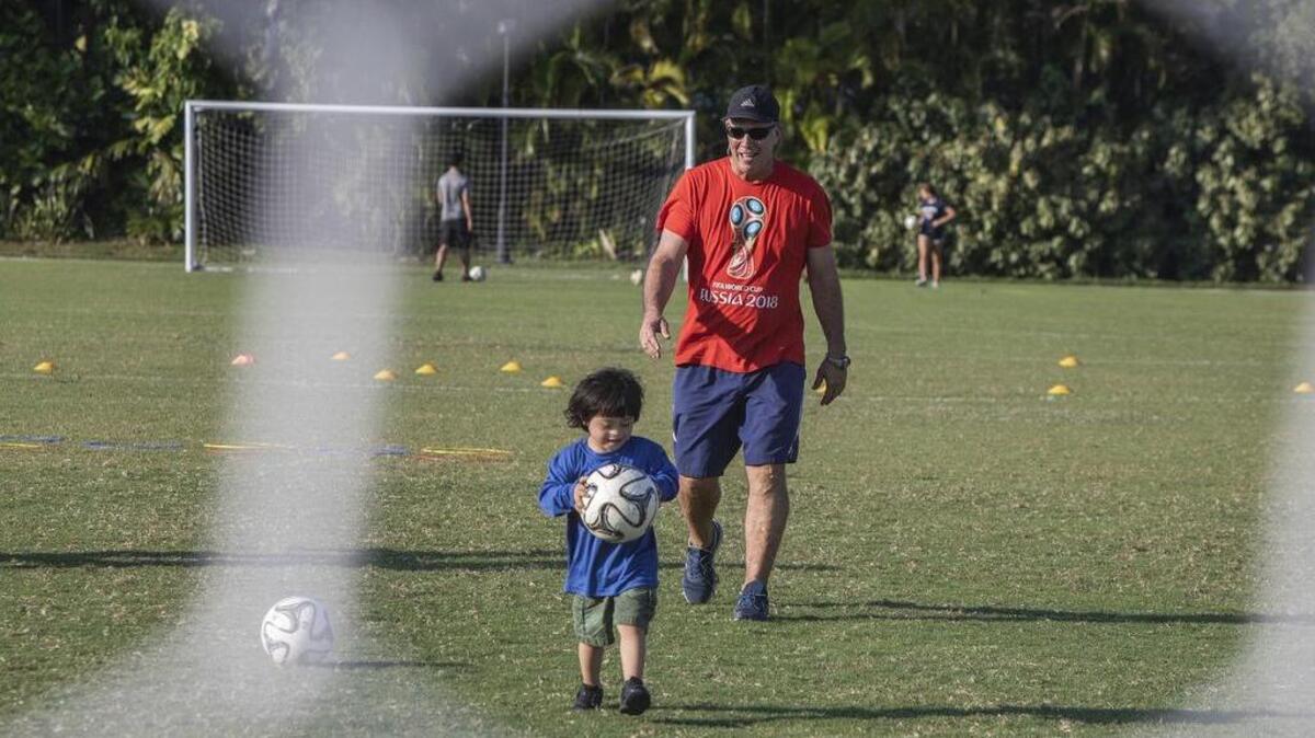 El entrenador, Antonio Paz, juega con Alejandro Herrera, de 4 años.