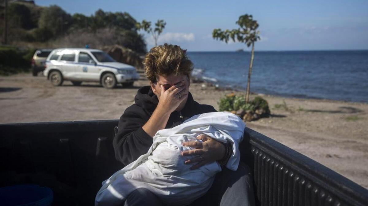 Fotografía de archivo de una mujer llorando mientras sostiene el cadáver de un bebé envuelto en una sábana en la isla de Grecia, Lesbos, el 30 de octubre de 2015.