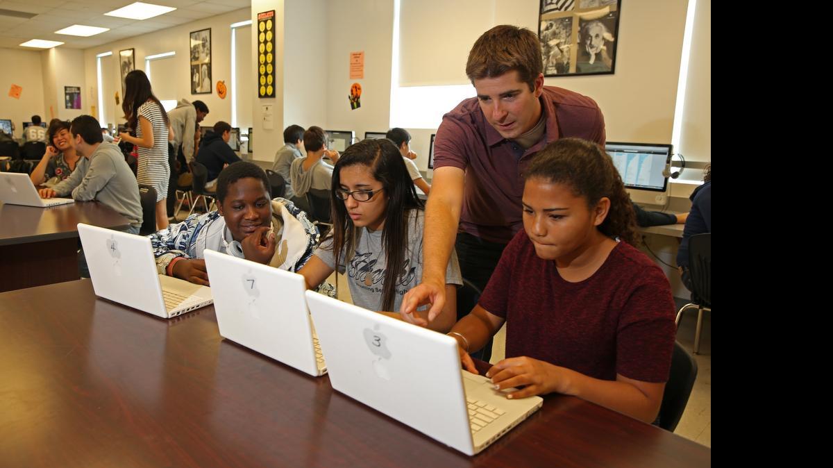 
En laboratorio de computadoras de Alonzo and Tracy Mourning Senior High School, Aaron Levin, profesor asociado de mercadeo entrena a los estudiantes Shon Hermilus, Salma El-Jurf y Corina Daniels (de izqda. a dcha.) cómo hacer una búsqueda correcta en la internet.


