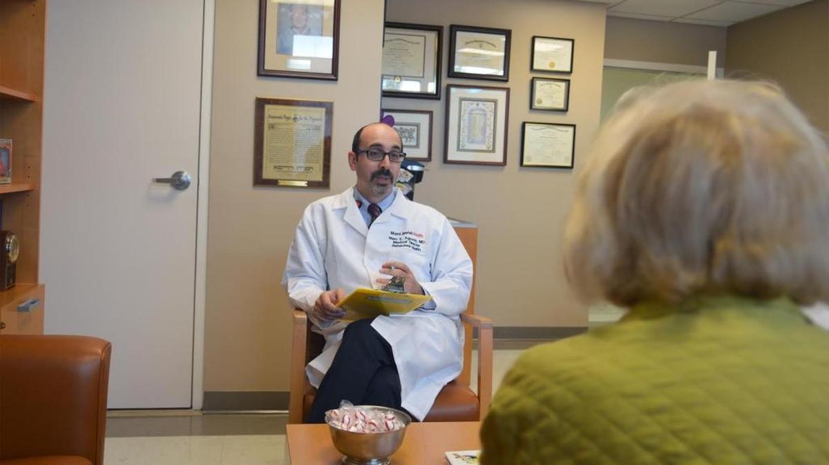 El Dr. Marc Agronin, director y fundador de centro de memoria y del programa de investigaciones clínicas de Alzheimer en el Miami Jewish Health, conversa con una paciente matriculada en el programa.