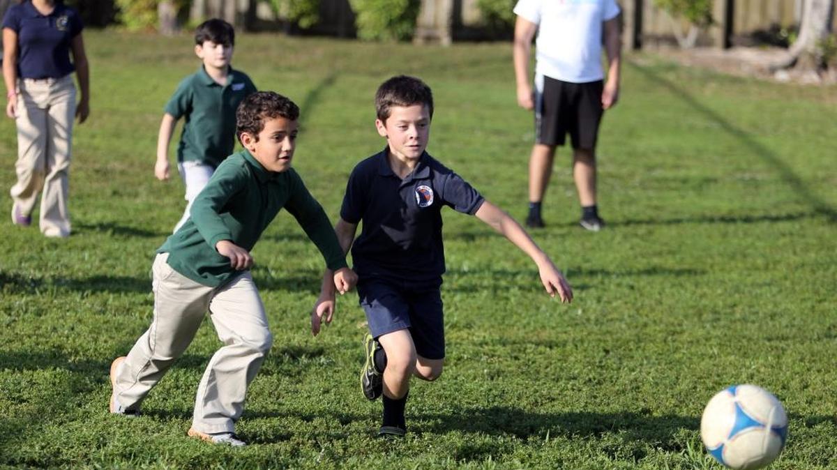 Dylan González, de 7 años, y Alexander Rodríguez participan de un juego de fútbol como parte del programa Fit2Play.