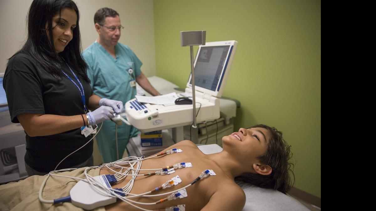 
Zachary Pena, está siendo sometido a un examen EKG por el cardiólogo Dr. Anthony Rossi del Nicklaus Children’s Hospital y la técnica Jennifer Ayala. Zachary juega béisbol y tiene un historial familiar de condiciones de corazón. 

