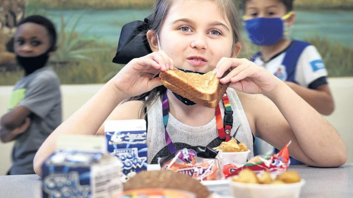 Margot McCormack, que cursa tercer grado en Heron Heights Elementary School, prueba un sándwich de queso como parte de la oferta escolar para almuerzos.