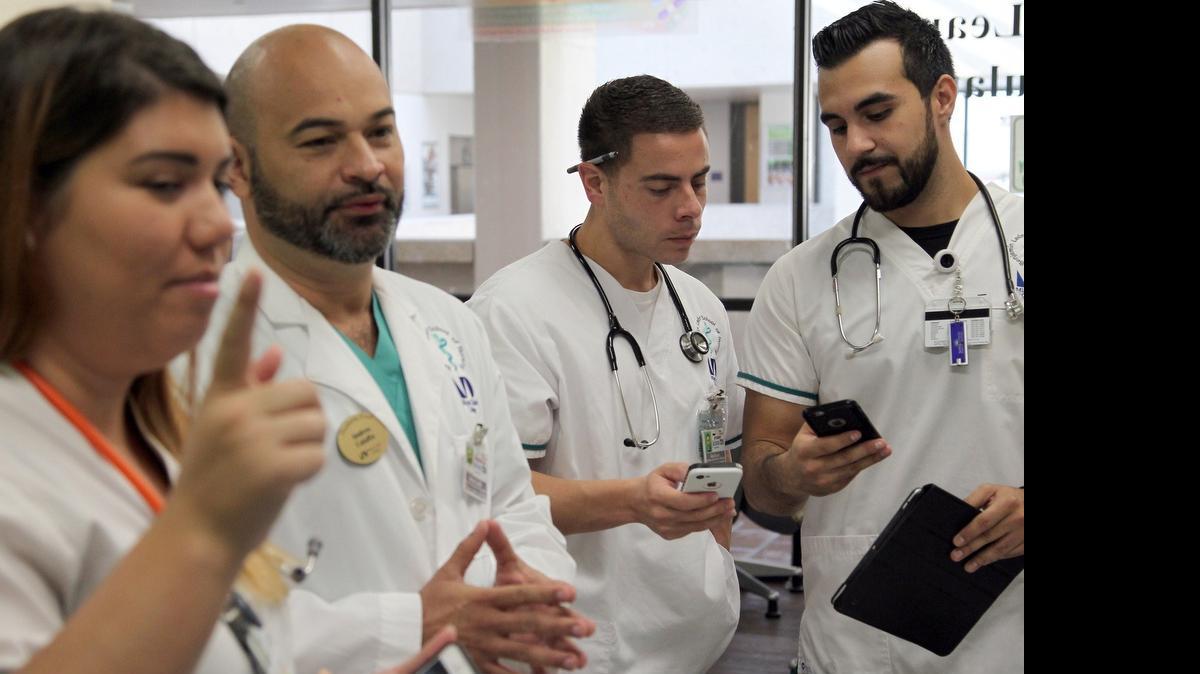 
El profesor Andrés Caiaffa de Miami Dade College Benjamin Leon School of Medicine permite que sus estudiantes utilicen tabletas y teléfonos celulares durante la clase. En la foto de izq. a der.: Cassandra González, el Prof. Andrés Caiaffa, Alex Escoto y Enrique Gil.
