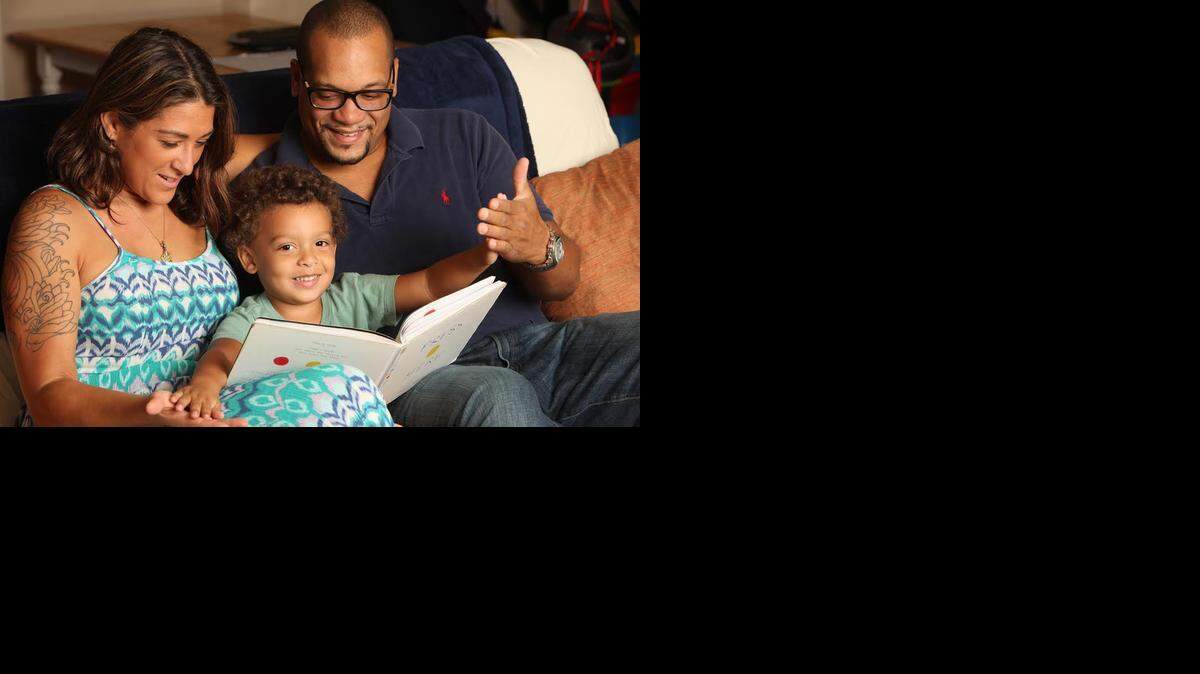 
Sarajane Weisberger (izq.) y Terry Gray (dcha.) leen con su hijo Xavier, de 3 años. Xavier fue diagnosticado con autismo y tiene problemas para procesar la información sensorial. 

