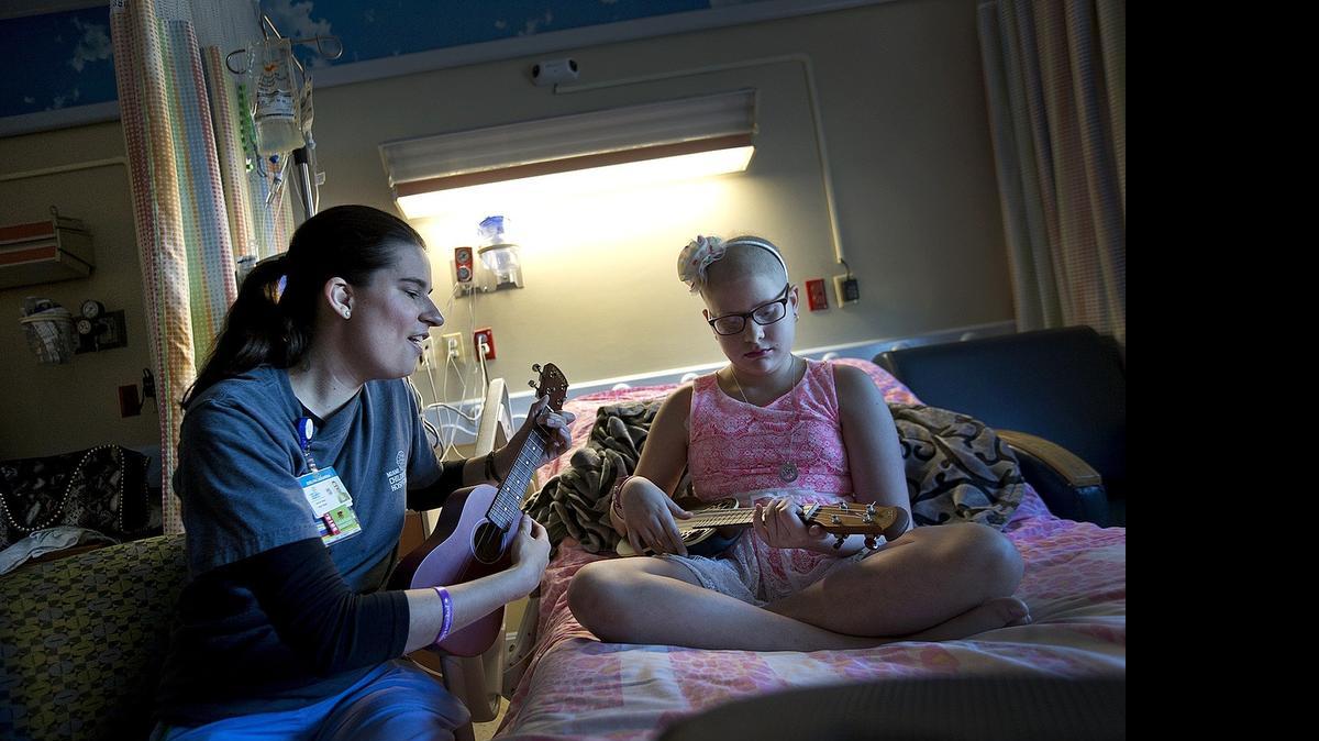 
La terapeuta de música Evelyn Laguardia enseña guitarra a Melissa Espinosa de 12 años. Melissa es paciente de cáncer en el Nicklaus Children's Hospital.

