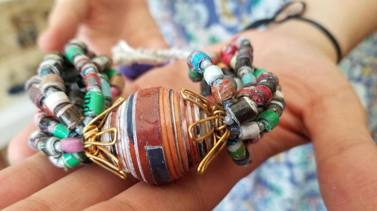 La diseñadora salvadoreña María Suriano muestra una pulsera confeccionada de papel de revista, alambre eléctrico y otros materiales reciclados, en Nueva York.