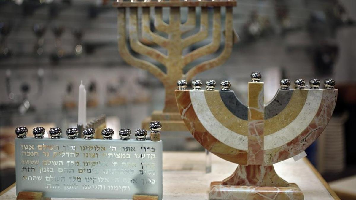 Estas menorahs, hechas de piedra y vidrio de Jerusalén por C.J. Art en Israel, están entre los artículos de la fe judía que ofrecen Hank y Roberta Seider en su tienda.