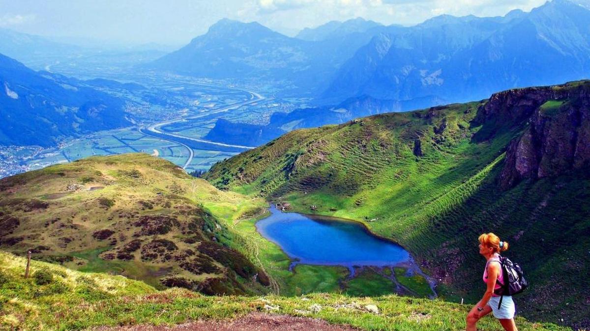Una mujer camina por el sendero sobre Paradiel, cerca de Bad Ragaz, Suiza, mientras disfruta del paisaje.