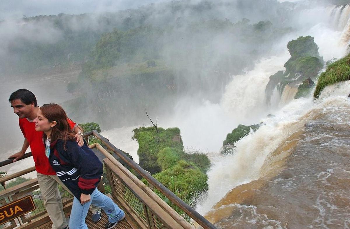 Una pareja de turistas disfruta del paseo que recorre distintas vistas de las Cataratas del Iguazú, una falla geológica declarada en 1984 Patrimonio Natural de la Humanidad.
