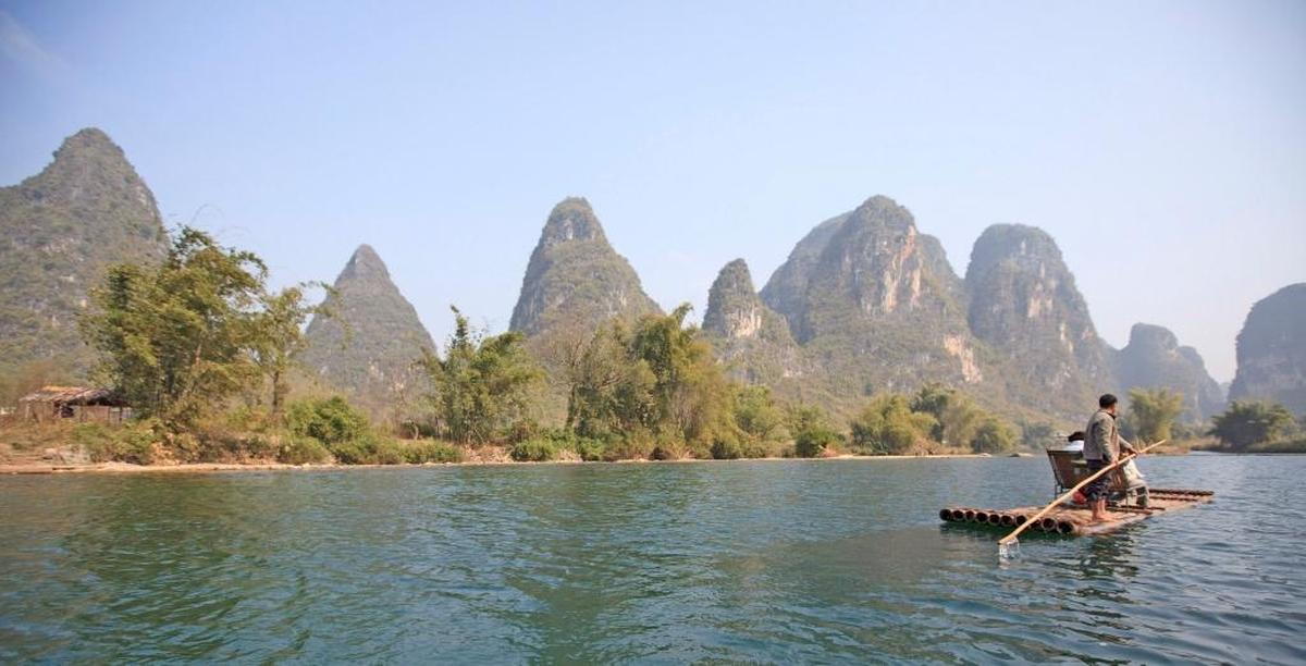 Un balsero local batea su balsa en un tramo del río Li a su paso por Yangshuo, al sureste de China.